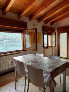 een eetkamer met een tafel, stoelen en ramen bij holiday on the island in Monte Isola