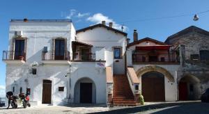 a white house with two motorcycles parked in front of it at Soprattutto in Montalbano Ionico