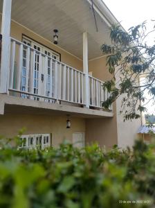 una casa con portico e balcone bianco di Casa cantinho do aconchego a Campos do Jordão