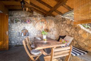 a dining room with a wooden table and chairs at Vila Dunjarica in Golubac