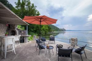 a patio with chairs and a table with an umbrella at Vila Dunjarica in Golubac