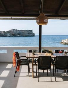 una mesa y sillas con vistas al océano en Beach front apartment with swimming pool, en Ligaria