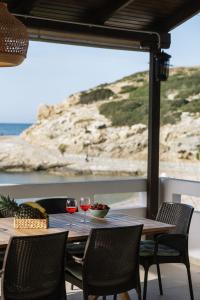 stolik z dwoma kieliszkami wina i widokiem na ocean w obiekcie Beach front apartment with swimming pool w mieście Ligaria