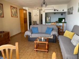 ein Wohnzimmer mit einem Sofa und einem Tisch in der Unterkunft EL PARAISO Piscina y Vistas a la costa in Mijas