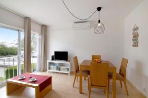 a living room with a dining room table and a television at Costa Cabanas 1 in Cabanas de Tavira