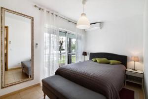 a bedroom with a bed and a mirror at Costa Cabanas 1 in Cabanas de Tavira +16 photos