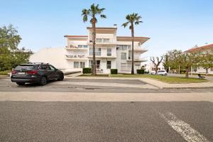 a car parked in a parking lot in front of a building at Costa Cabanas 1 in Cabanas de Tavira