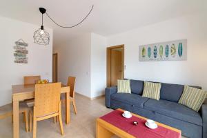 a living room with a blue couch and a table at Costa Cabanas 1 in Cabanas de Tavira