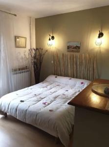 1 cama en un dormitorio con mesa y luces en Villa entre Nîmes et le Pont du Gard, en Bezouce