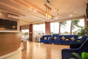 a living room with blue furniture and large windows at منتجع خيالي السياحي 1 in Khamis Mushayt