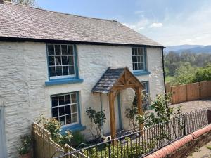 a white brick house with a wooden door at Avondale in Llangollen