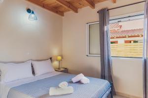 una camera da letto con un letto con asciugamani sopra di Burnelia Vacation House a Lefkimmi