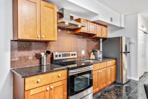 a kitchen with wooden cabinets and a stove top oven at Cozy 1BD steps away from Convention Center in Philadelphia