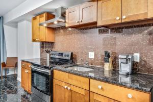 a kitchen with wooden cabinets and a sink at Cozy 1BD steps away from Convention Center in Philadelphia