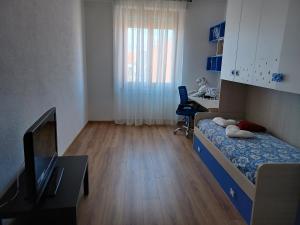 Kleines Zimmer mit einem Bett, einem Schreibtisch und einem Fenster in der Unterkunft Nikità in Venaria Reale