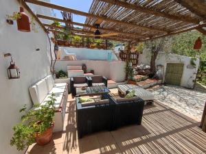 patio con divani e sedie sotto un pergolato di Cortijo Aldamuz a Oria