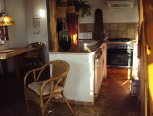 cocina con fogones y mesa con silla en Casa da Praia 1, en Budens