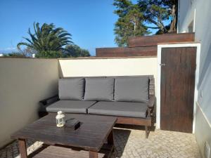 eine Couch auf einer Terrasse mit einem Tisch in der Unterkunft Lopes Apartment - Belch1952 in Lagos