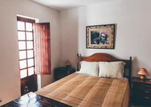 1 dormitorio con 1 cama y una foto en la pared en Casa da Praia 1, en Budens