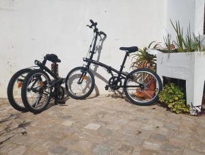 Dos bicicletas están estacionadas junto a una pared. en Casa da Praia 1, en Budens