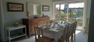 a dining room with a table with chairs and a mirror at CORSBIE VILLA GUEST HOUSE in Newton Stewart