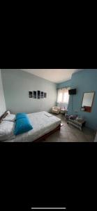 a bedroom with a bed and a blue wall at Seaside apartment with private garden in Nea Anchialos