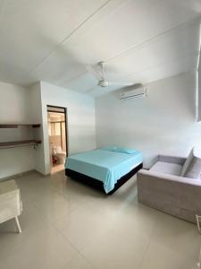 a bedroom with a bed and a couch in it at Casa campestre in Ricaurte