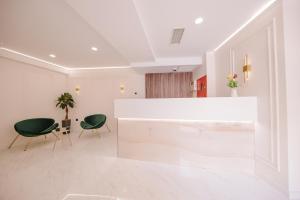 a lobby with two green chairs and a white counter at Orden Hotel in Tbilisi City