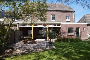 a brick house with a patio in the yard at B&B de Blauwververij in Blitterswijck