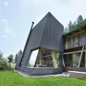 ein schwarzes Haus mit einem großen Fenster in der Unterkunft Stadlnest Moser in Neustift im Stubaital