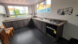 a small kitchen with a stove and a sink at Tauko tu casa in Paipa