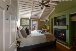 a bedroom with a bed with a fireplace and a ceiling fan at Inn Above Oak Creek Sedona in Sedona