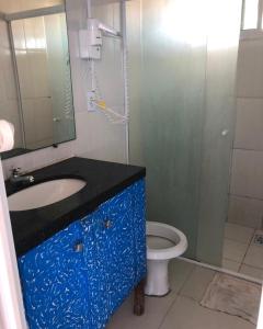 une salle de bain avec un lavabo bleu et des toilettes dans l'établissement Apartamento Vista Magnífica frente ao mar, à Luis Correia