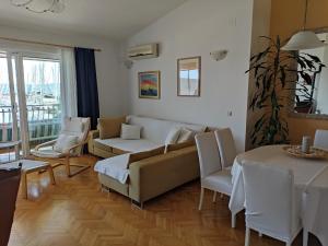 - un salon avec un canapé, des chaises et une table dans l'établissement Apartment Gallery, à Kaštela