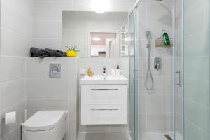 a white bathroom with a toilet and a shower at Luxury in City -3- Studio Bright & Secure Free Parking in Łódź