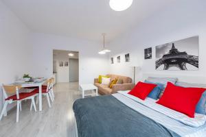 a bedroom with a bed with red pillows and a table at Luxury in City -3- Studio Bright & Secure Free Parking in Łódź