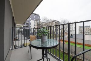 a balcony with a table and a potted plant on it at Luxury in City -3- Studio Bright & Secure Free Parking in Łódź
