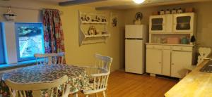 a kitchen with a table and a white refrigerator at Wsiowa Chata in Ścinawka Górna