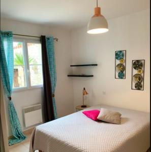 a bedroom with a bed with a pink pillow on it at Villa de 4 chambres avec piscine partagee a Meschers sur Gironde in Meschers-sur-Gironde