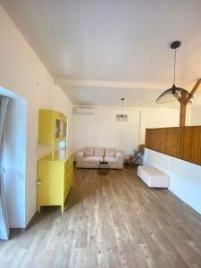 a living room with a couch and a yellow cabinet at FOTIS HOUSE in Koroni