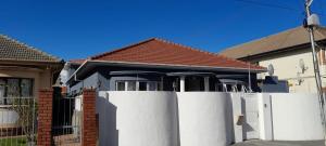 a white fence in front of a house at Jacmo Guest Private Rooms in Cape Town