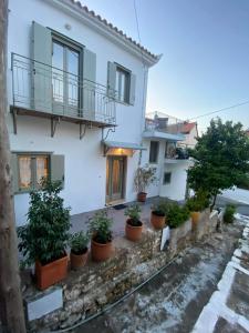 a white house with potted plants in front of it at FOTIS HOUSE in Koroni