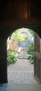 an archway leading to a garden with a fountain at Riad Dar Zaida in Marrakech