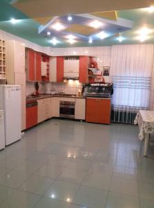 a large kitchen with white appliances and red cabinets at Casa Albastra in Drumu Carului