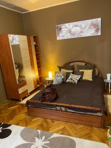 a bedroom with a large bed and a mirror at Széll 3 Apartman in Szombathely