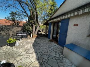 圖雷特的住宿－Maison dans domaine privé，一座带蓝色门和石头走道的建筑