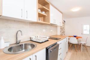 eine Küche mit weißen Schränken und einem Waschbecken in der Unterkunft Casa del Mare Bjelila in Tivat