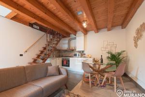 ein Wohnzimmer mit einem Sofa und einem Tisch in der Unterkunft MURANO Place - RIVA House in Murano