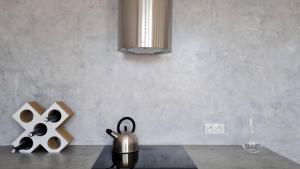 un bancone della cucina con bollitore e lampadario. di Apartmán Polygon a Valtice