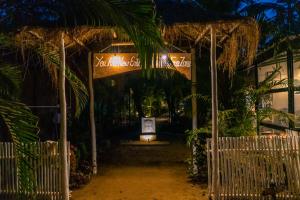 Una entrada a un restaurante por la noche con un cartel en Village Susegat Beach Resort, en Morjim